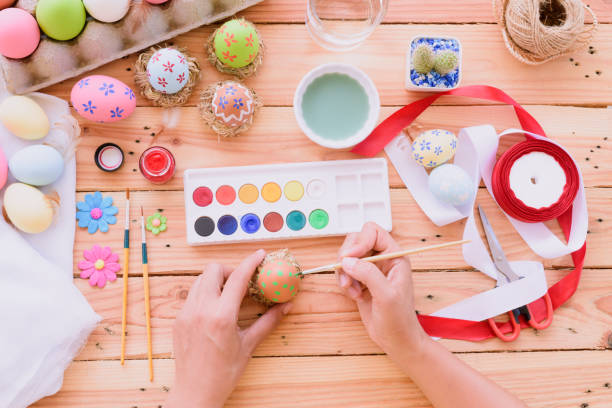 istock Happy easter! A woman hand painting Easter eggs. Happy family preparing for Easter. 939184048