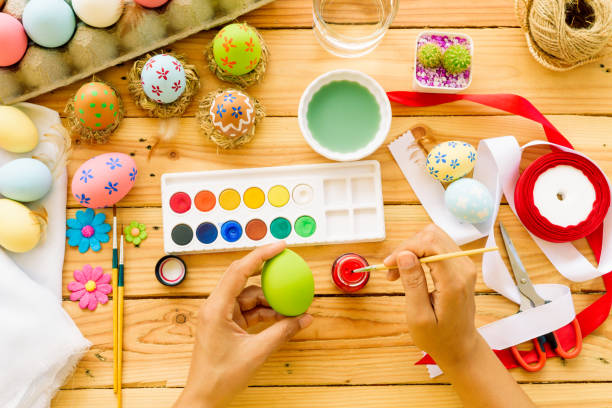 istock Happy easter! A woman hand painting Easter eggs. Happy family preparing for Easter. 939184124