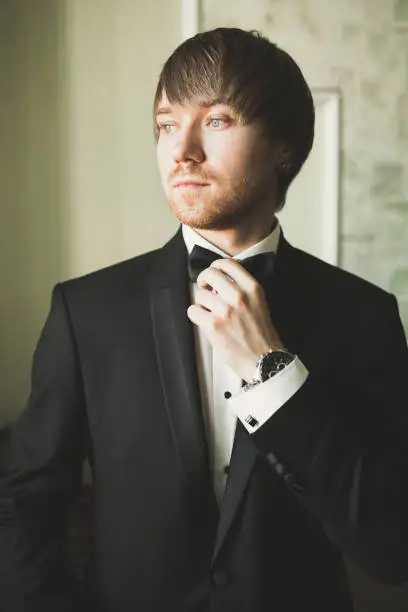 Photo of Beautiful man, groom posing and preparing for wedding