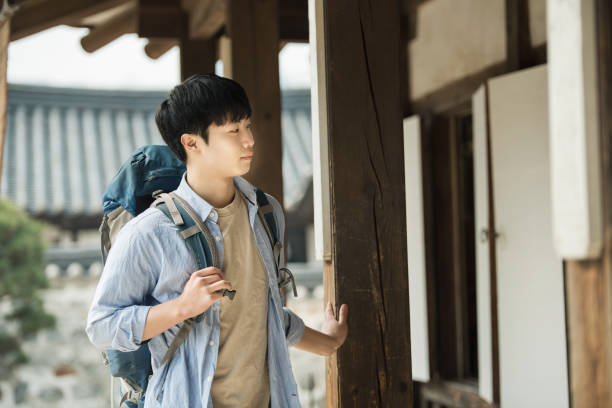 istock young man doing a backpacking trip in a Korean traditional house. 939189410