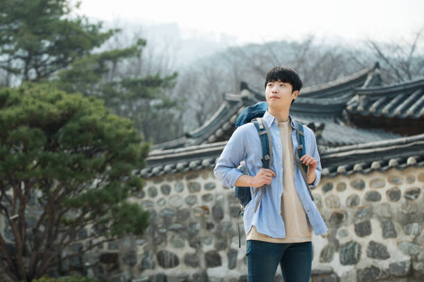 A young man doing a backpacking trip in a Korean traditional house.