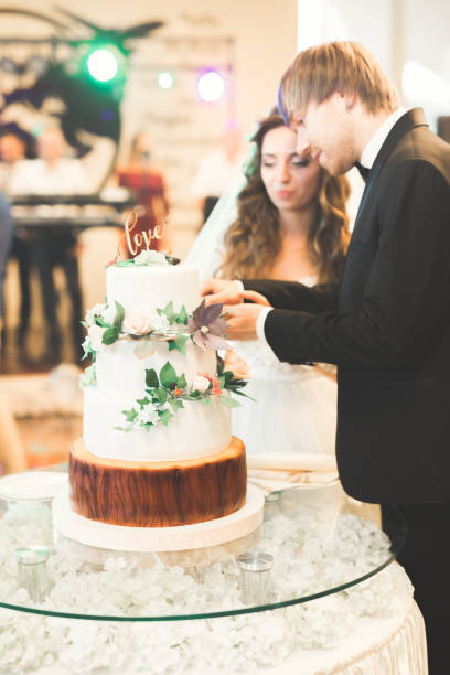 istock Bride and groom at wedding cutting the wedding cake 939189544