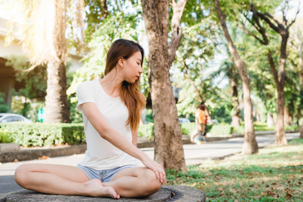 istock Young asian woman yoga outdoors keep calm and meditates while practicing yoga to explore the inner peace. Yoga and meditation have good benefits for health. Yoga Sport and Healthy lifestyle concept. 939189694