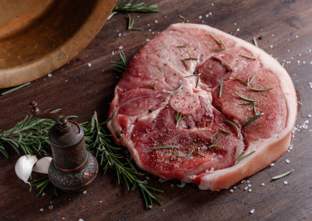 istock Raw pork with rosemary , salt and pepper. 939194608