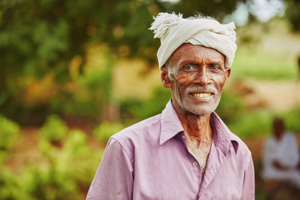 An old man is sitting in dull white clothes.