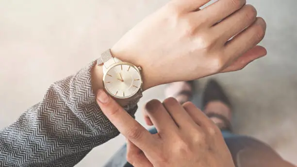 Photo of Woman looking her watch stand up