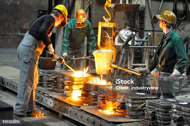 Group Of Workers In A Foundry At The Melting Furnace Production Of Steel Castings In An Industrial Company Stock Photo - Download Image Now