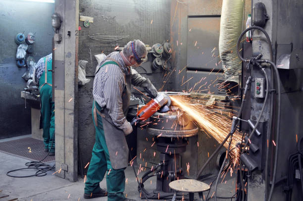 istock Workers in a foundry grind castings with a grinding machine - Heavy industry workplace 939203124