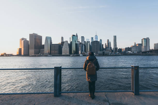 giovane donna in piedi di fronte a manhattan - new york city new york state skyline winter foto e immagini stock