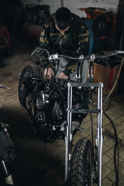 istock Man worker in motorcycle repair shop 939210716