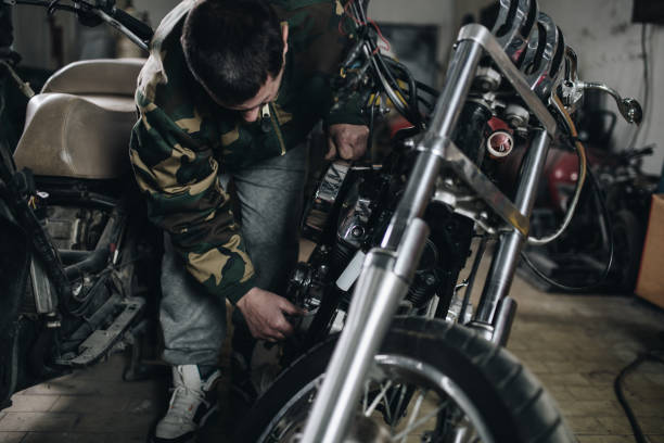 istock Man worker in motorcycle repair shop 939210732