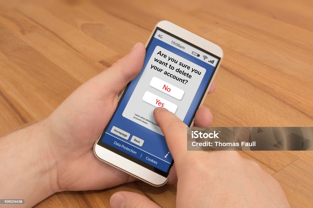 Using a smartphone to delete an online account Using a smartphone to delete an online account, finger over Yes to delete.
+  screen design is an original mock up, phone has buttons and ports removed Social Media Stock Photo