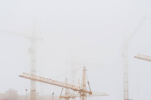 istock yellow tower cranes in misty haze 939219242