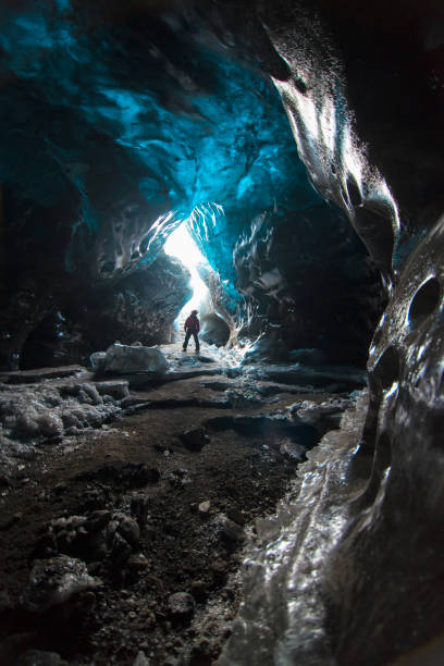 grotta di ghiaccio nel sud dell'islanda in inverno. piccola sagoma dell'uomo in esso - skaftafell glacier foto e immagini stock