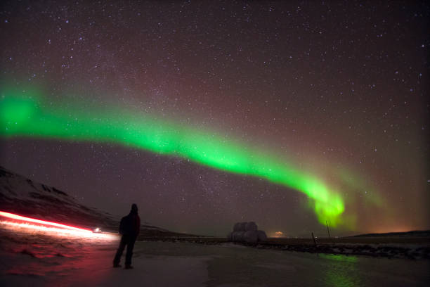 istock man stand on farm with white wrap grass stack cover sky by aurora borealis and milky way in Iceland winter. 939222818