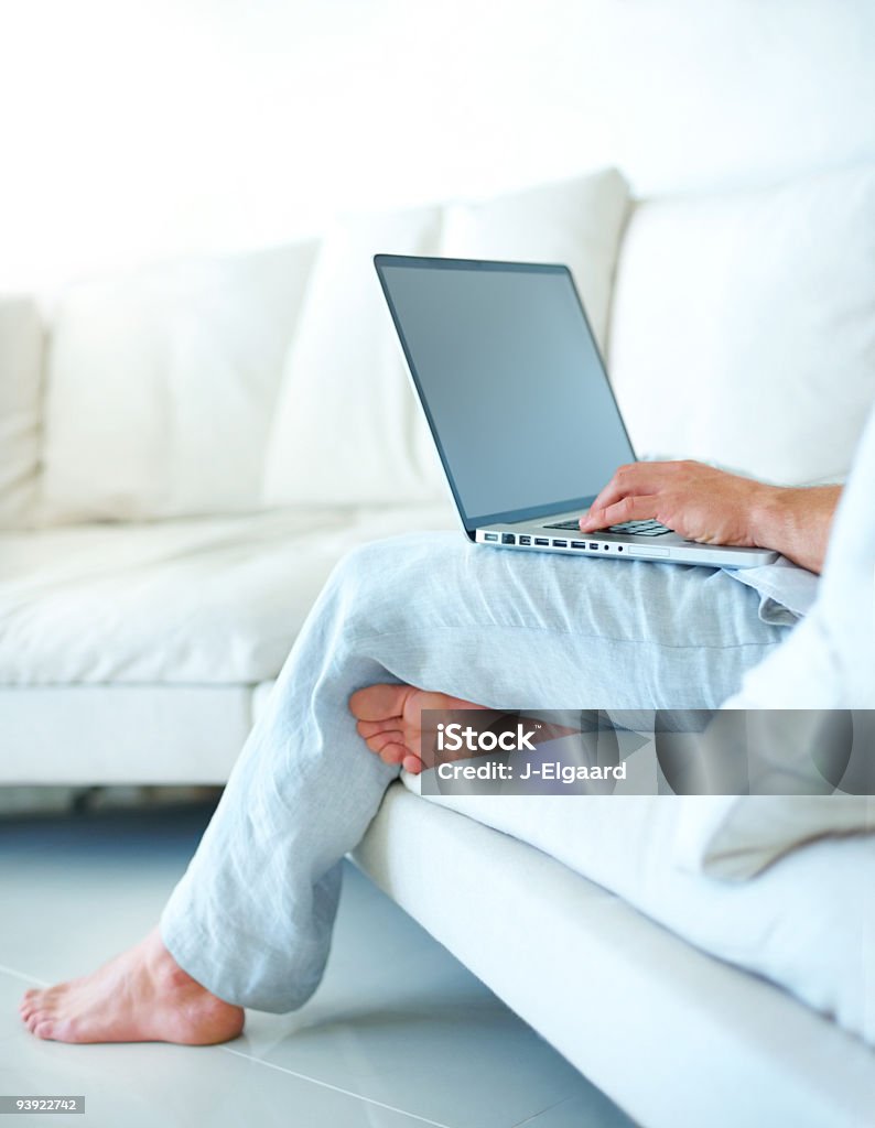 Lowsection de un hombre usando una computadora portátil - Foto de stock de Personas libre de derechos