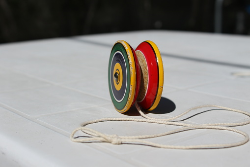 In the picture you can see a brightly colored toy called Yo-yo, with the loose rope, on top of a white table ready to use.