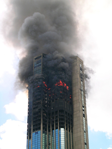 A modern skyscraper glass building on fire in Central Park, Caracas Venezuela