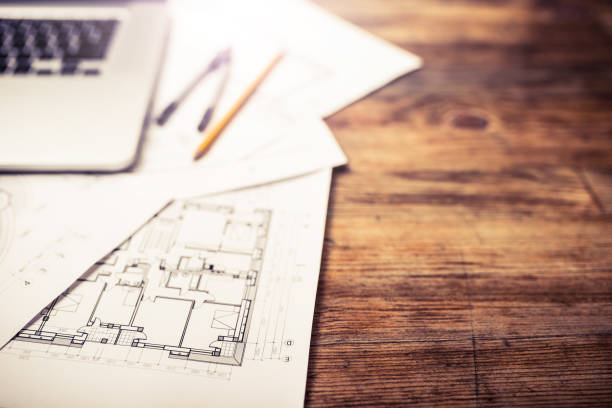 istock Laptop and architectural blueprints on a wooden desk 939232318