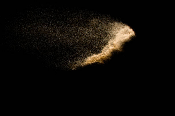 istock Abstract sand cloud. Golden colored sand splash agianst dark background. Yellow sand fly wave in the air. Sand explode on black background ,throwing freeze stop motion. 939238654
