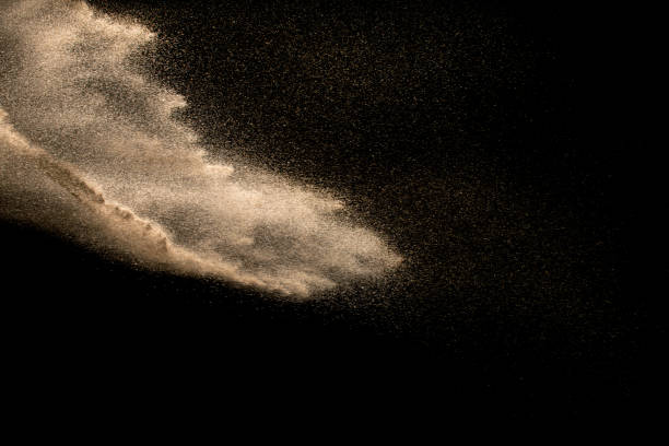 istock Abstract sand cloud. Golden colored sand splash agianst dark background. Yellow sand fly wave in the air. Sand explode on black background ,throwing freeze stop motion. 939238690