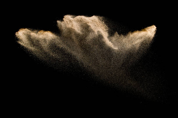 istock Abstract sand cloud. Golden colored sand splash agianst dark background. Yellow sand fly wave in the air. Sand explode on black background ,throwing freeze stop motion. 939238770