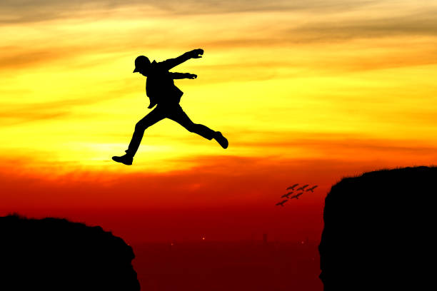 istock Silhouette of a man jumping over the cliff 939238866
