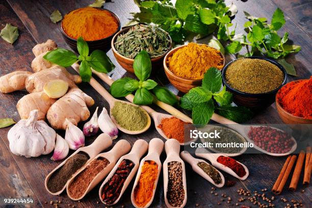 Variety Of Spices And Herbs On Kitchen Table Stock Photo - Download Image Now - Spice, Basil, Bowl