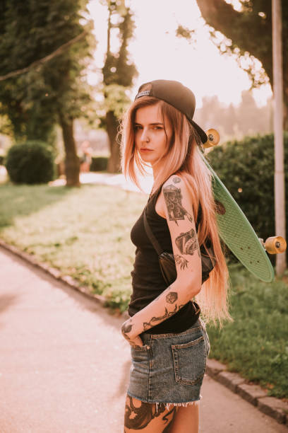 istock Beautiful tattooed girl with skateboard 939245114