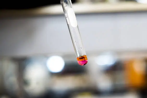 2 layers color pink and orange solution in test tube in laboratory