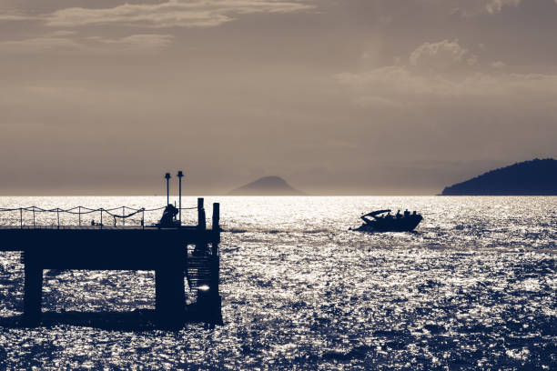 Sunset with ship on horizon and pier in foreground