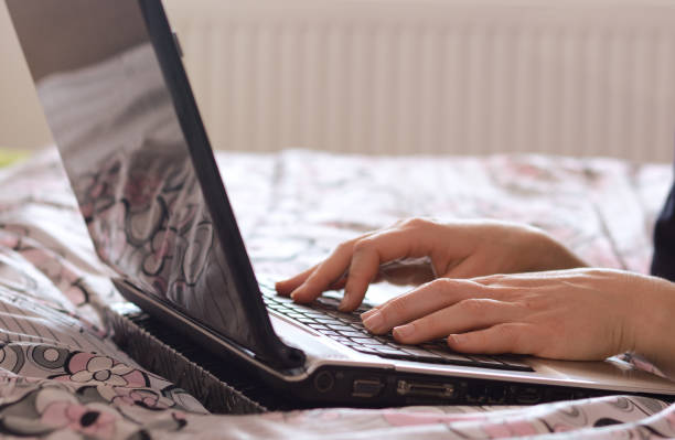 istock Female blogger using laptop in bed 939260602