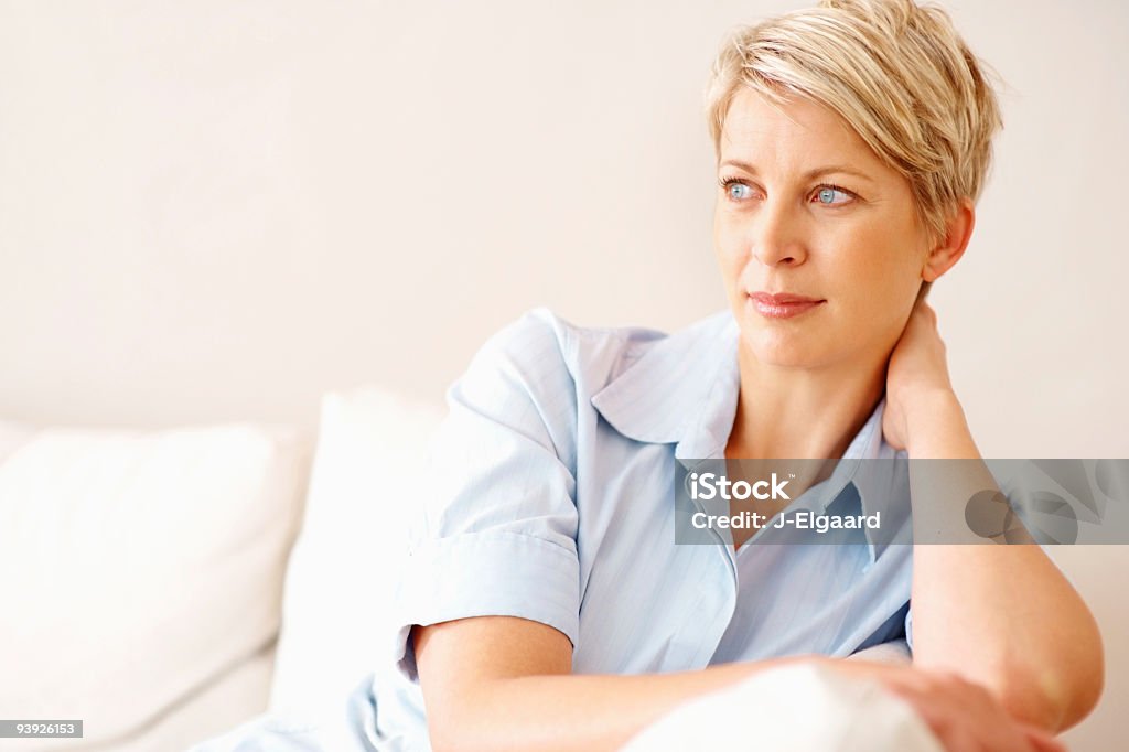 Vista di un contemplativo medio invecchiato donna a casa - Foto stock royalty-free di 30-34 anni