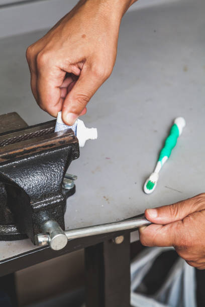 istock Hand inserts coiled tube of toothpaste in bench screw 939262038