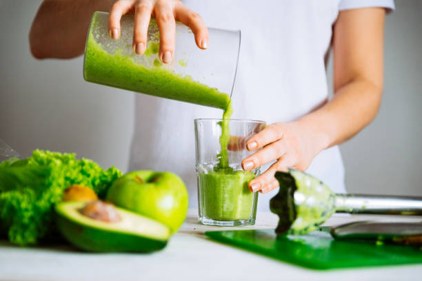 mujer transfundir batido al vidrio. concepto de comida saludable - desintoxicación fotografías e imágenes de stock