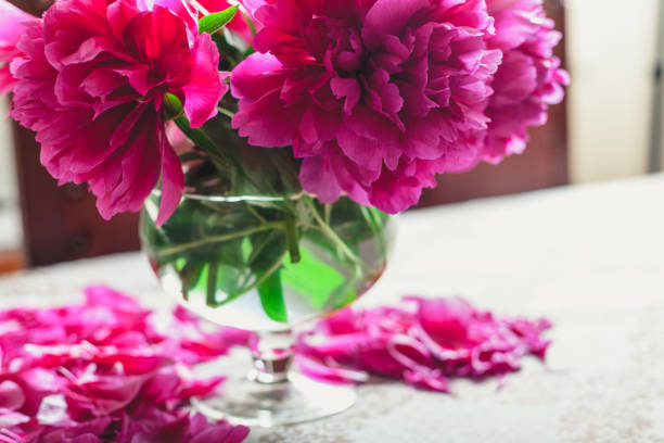 istock red peonies in glass vase stand on table 939263256