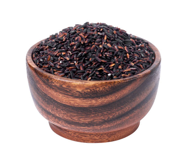 istock Black rice in wooden bowl isolated on white background 939269008