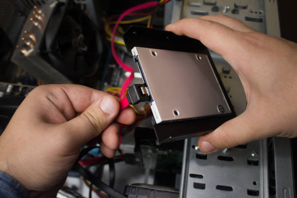 SSD drive computer connection. First person view hands connecting SSD drive & cables to a motherboard. solid state disk photos stock pictures, royalty-free photos & images