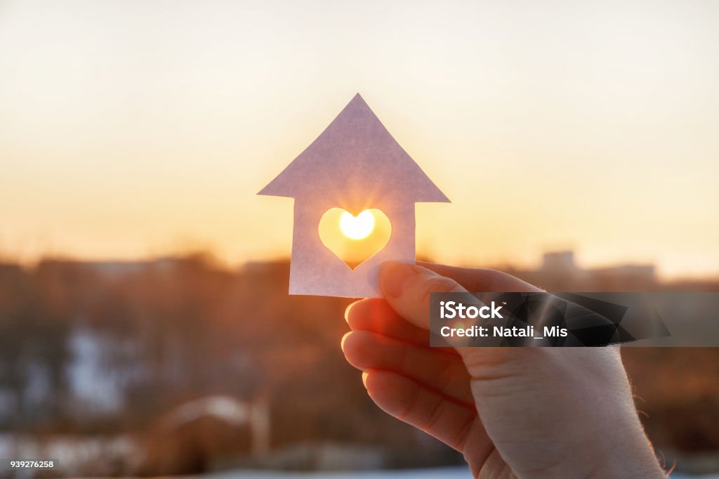 Casa de papel con un corazón en la mano. - Foto de stock de Casa libre de derechos