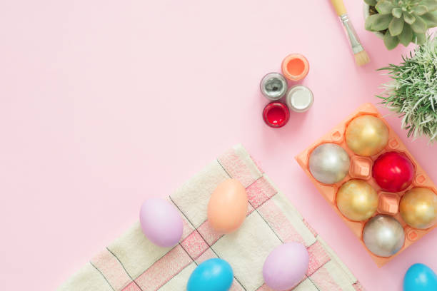 istock Flat lay top view colorful easter egg painted in pastel colors composition with paint brush on pink pastel color background. Easter day background top view with copy space. 939280340
