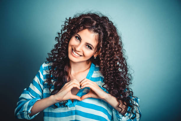 istock woman making heart sign with hands 939281064