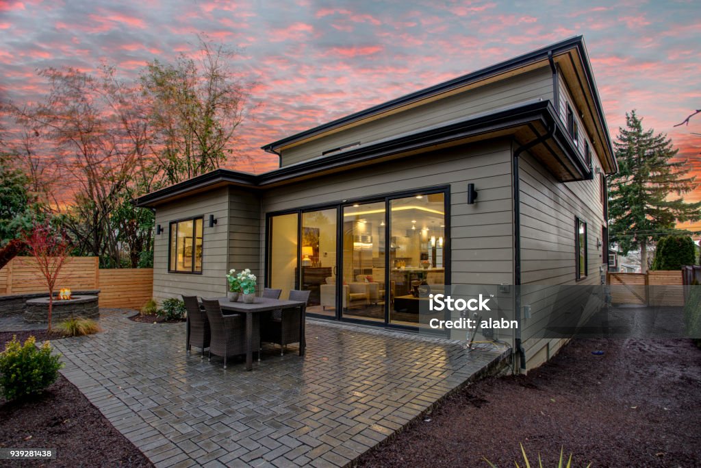 Modern house exterior with a deck at sunset. Modern house exterior with a spacious deck at sunset. House Stock Photo