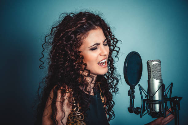 Singer. Woman lady girl singing with microphone singing stock photo