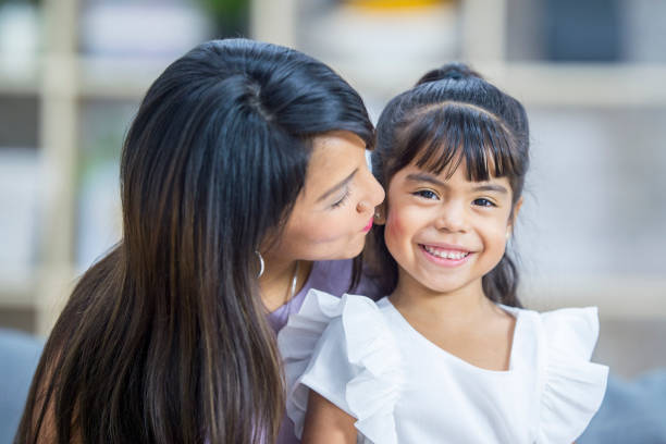 istock Mom kissing her daughter's cheek 939282570