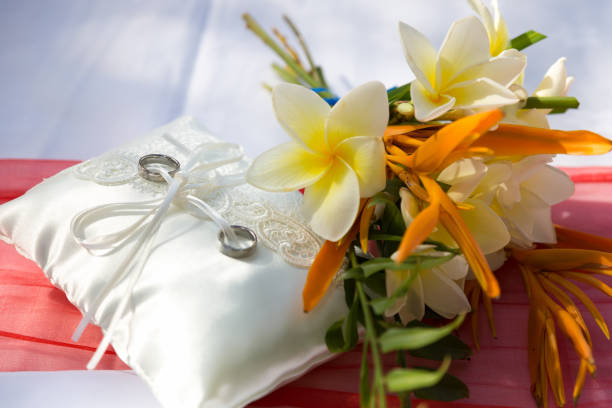 istock Wedding rings on the lace pillow with tropical flowers 939287232
