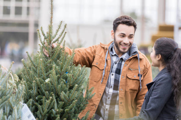 istock Young man shows Christmas tree to wife 939287608