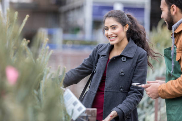 istock Home improvement store salesperson assists customer with Christmas tree selection 939287628