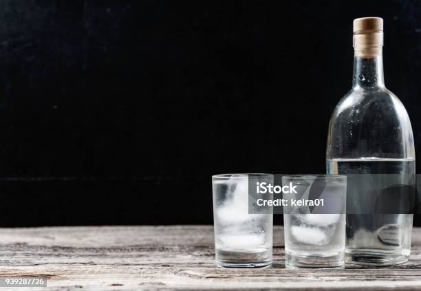 Cold Vodka In Shot Glasses On A Black Background Stock Photo - Download Image Now - Vodka, Bottle, Shot Glass