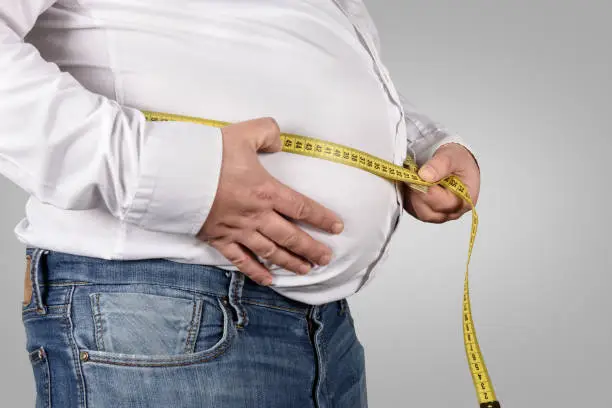 Photo of Overweight Man Measuring His Belly with tape measure