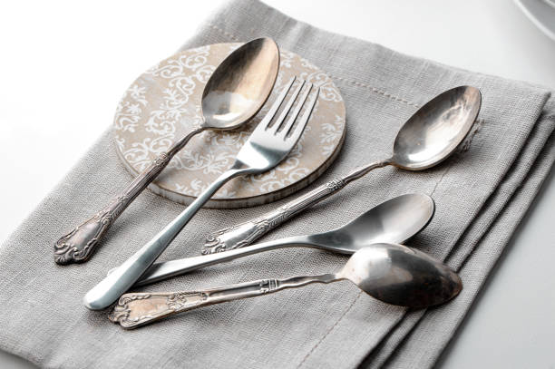 teaspoons and fork with linen napkin close-up on white background